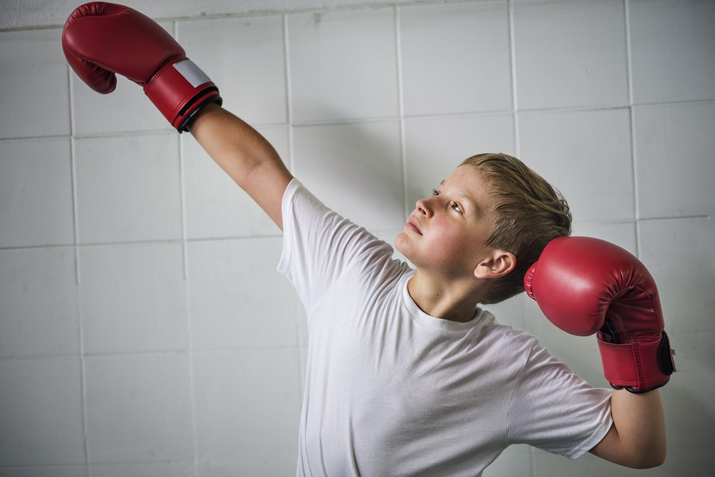 Confident boy posing with boxing gloves