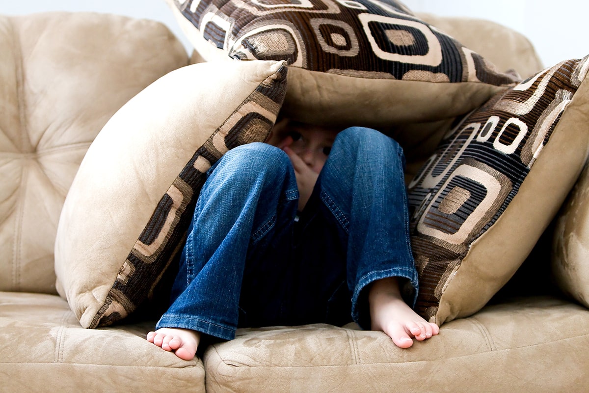 Child hiding in pillow fort